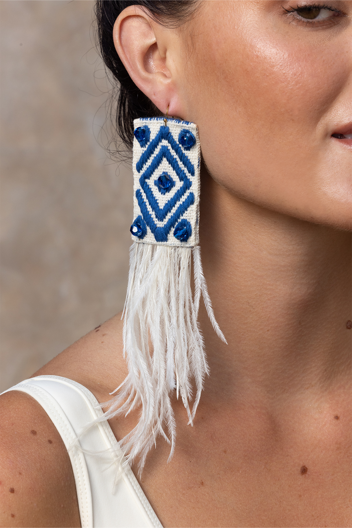 Boucles d'oreilles pendantes Flamingo ornées de plumes blanches et de motifs brodés bleus, pour une allure audacieuse et raffinée.