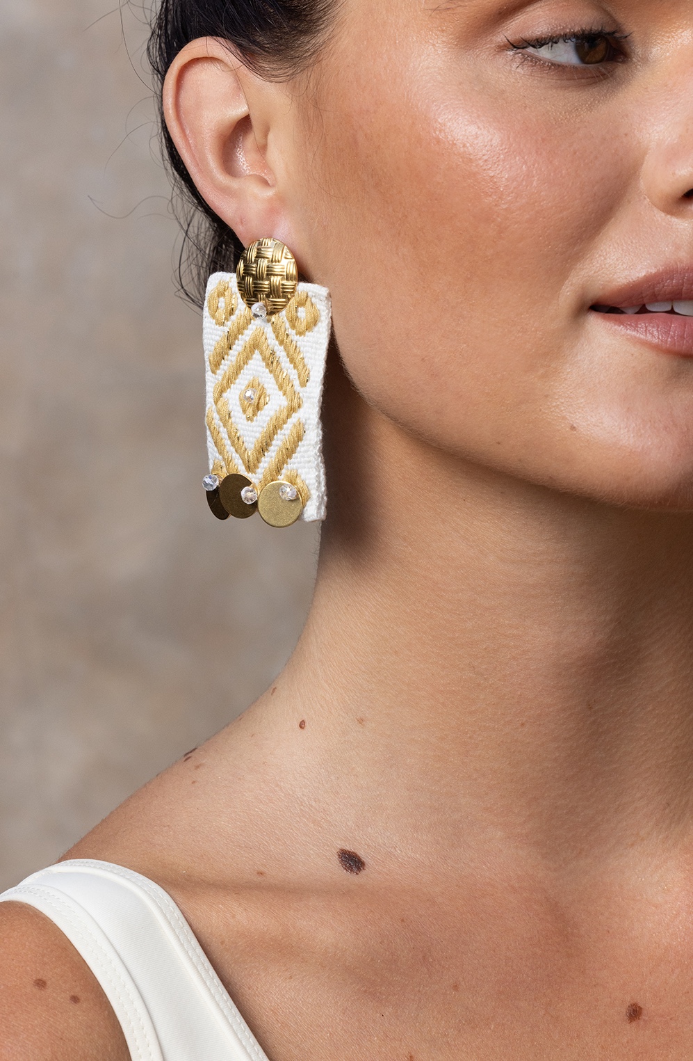 Boucles d'oreilles pendantes Blusing en doré avec motifs brodés et pampilles, pour un style glamour et raffiné.